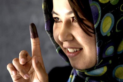 An Afghan woman reveals the ink on her finger – indicating that she cast her vote.